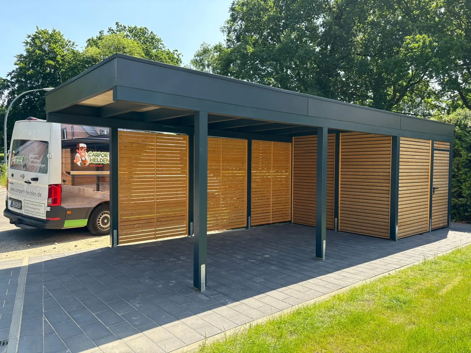Montage-Transporter von Carport Helden vor einem fertigen Doppelcarport mit Lärchenwänden