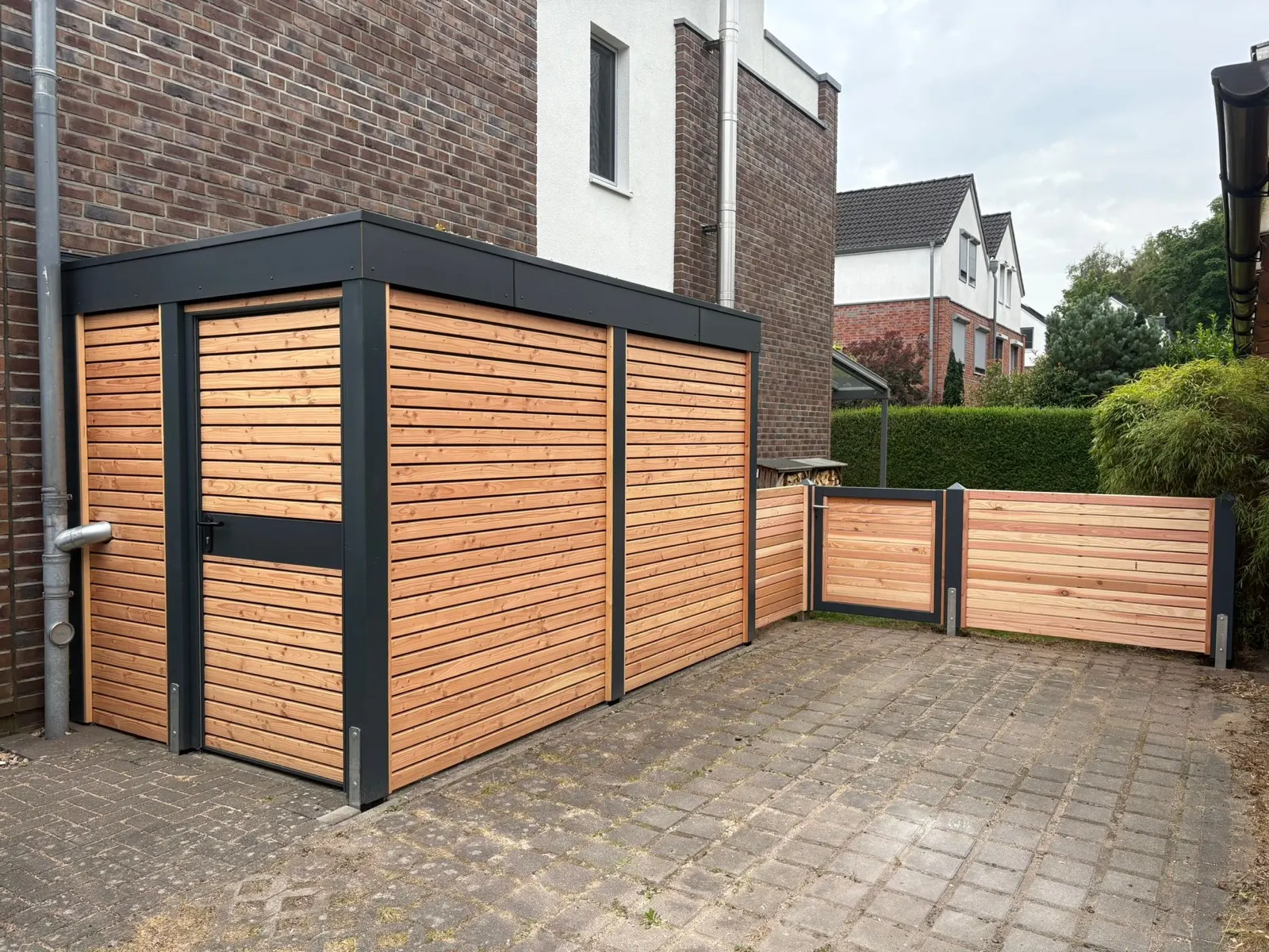 Hofsituation mit Carport, Mülltonnen-Einhausung und Sichtschutz aus Lärchenholz aus einer Hand