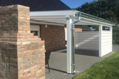 Weiße Überdachung am Klinkerhaus, kombiniert mit anschließendem Carport